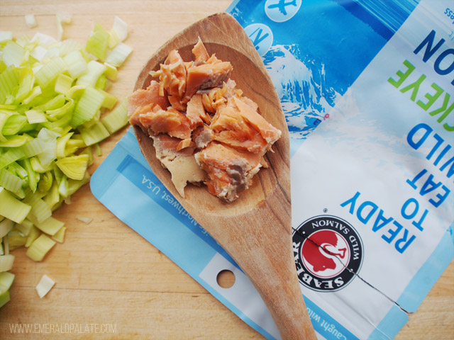 close up of canned salmon on a spoon, a pantry staple for how to stock your pantry for the first time